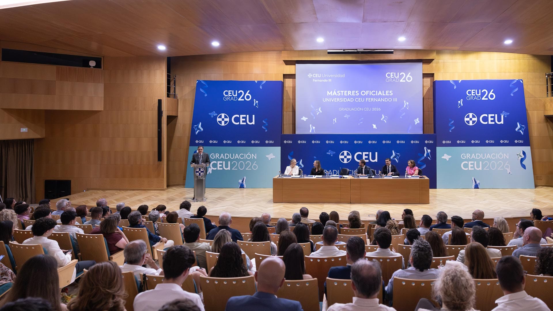 Auditorio lleno de público y graduados con becas en la ceremonia de un máster en la CEU UF3.