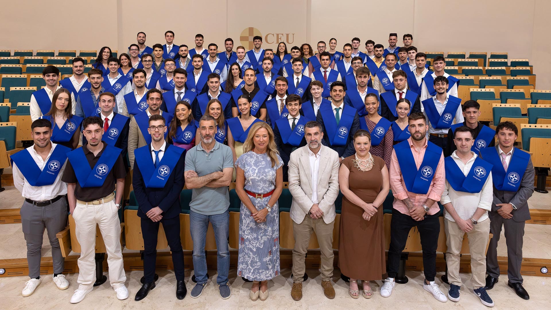 Foto de grupo de graduados con becas azules y autoridades académicas en la ceremonia de un máster en la CEU UF3